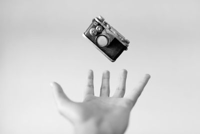 Close-up of hand holding paper over white background