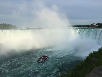 Scenic view of waterfall against sky