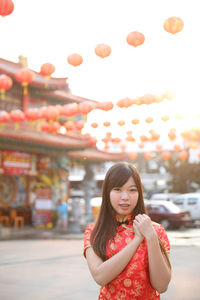 Portrait of a smiling young woman standing against sky