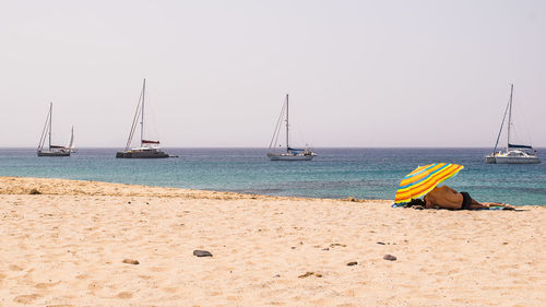 Sailboats in sea against clear sky