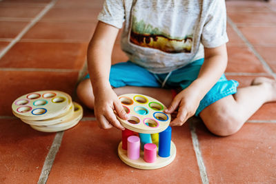 Low section of boy playing with toy