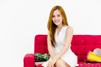 Portrait of a smiling young woman sitting on sofa