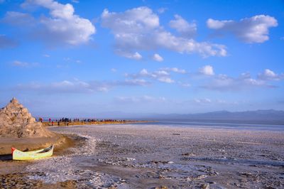 Scenic view of dry salt lake against cloudy sky