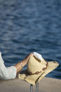 Person holding hat on beach