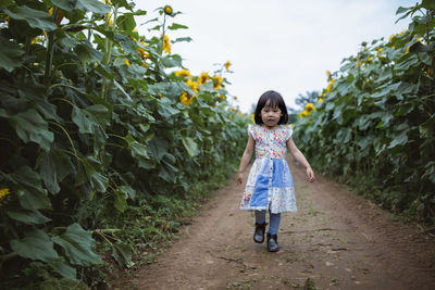 Full length of girl standing against plants