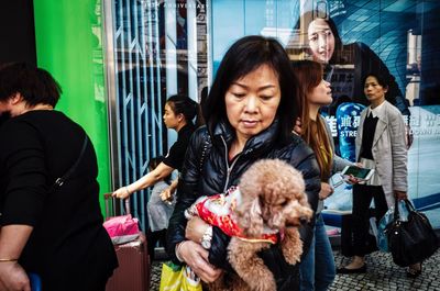 Friends standing with dogs in city