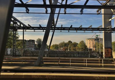 Railroad tracks and bridge in city against sky