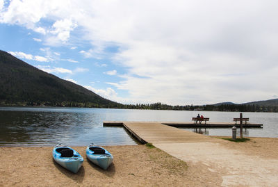 Scenic view of lake and mountain against cloudy sky