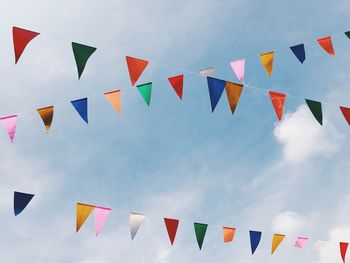 Low angle view of colorful buntings hanging against sky