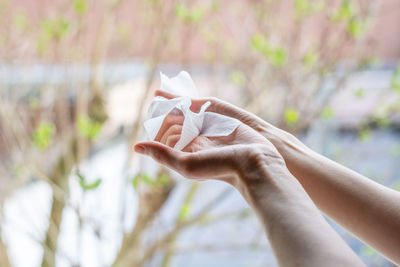 Close-up of hand holding paper against blurred background