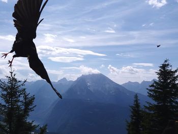 Man flying over mountain against sky