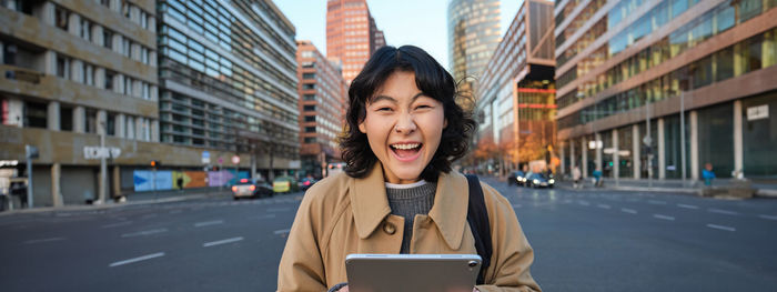 Young woman using mobile phone in city