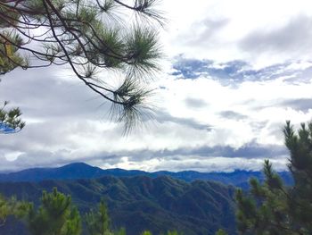 Scenic view of mountains against cloudy sky