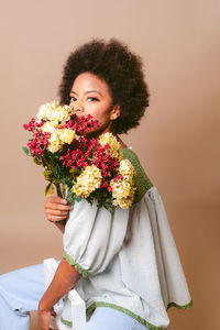 Portrait of smiling young woman with bouquet