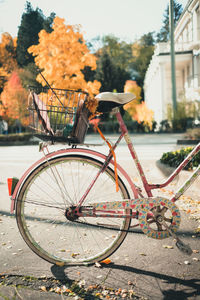 Bicycle with flat wheel and painted with hearts in the city on a sunny autumn day.