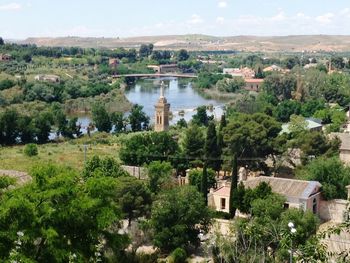 Scenic view of town by river against sky