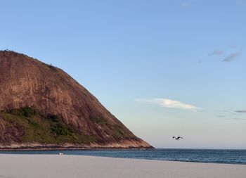 Scenic view of sea and mountains against sky