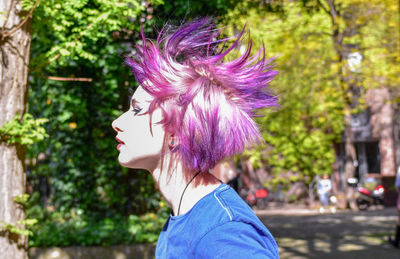 Side view of hipster woman with dyed purple hair outdoors