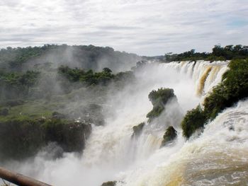 Scenic view of waterfall against sky