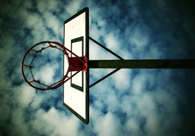 Low angle view of basketball hoop against ble cloudy sky, sport abstract