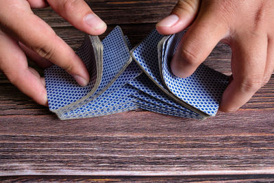 Cropped hand playing poker at table