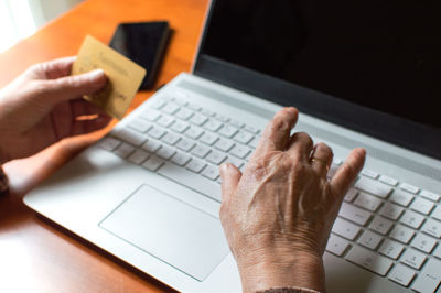 Midsection of person using mobile phone on table