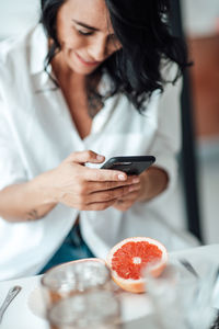 Midsection of woman holding ice cream on table