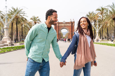 Portrait of smiling couple standing against building