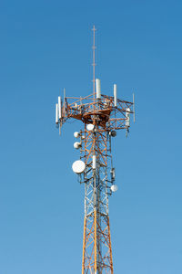 Low angle view of communications tower against blue sky