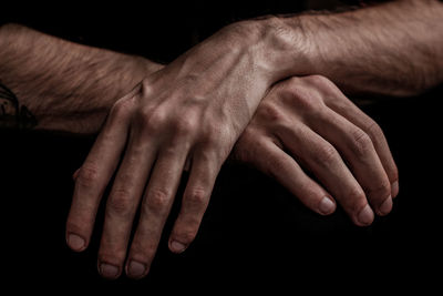 Cropped image of hands against black background