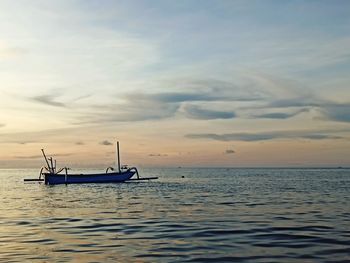 Sailboat in sea against sky during sunset