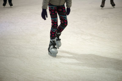 Low section of child skateboarding on ice rink