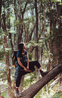 Rear view of woman standing in forest
