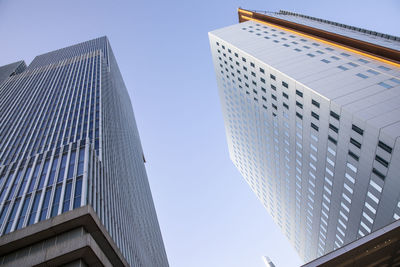 Low angle view of modern buildings against clear blue sky