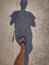 Low section of man standing on road