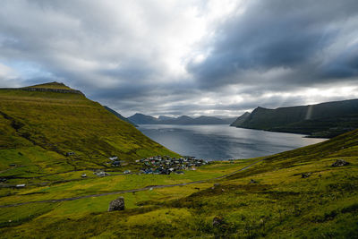 Scenic view of river and mountains against sky