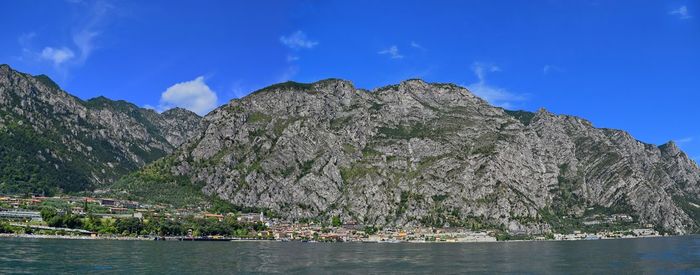 Panoramic view of sea and mountains against blue sky