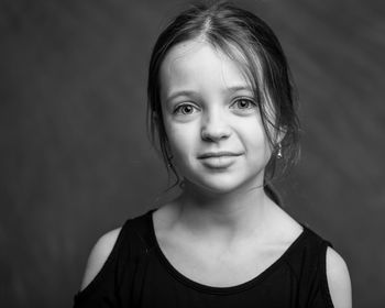 Portrait of smiling girl against black background