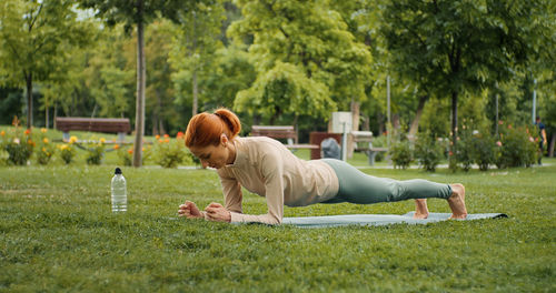 Woman is planking outdoor during fitness session. 