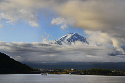 Scenic view of sea by mountains against sky