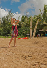 Full length of woman standing on beach against sky