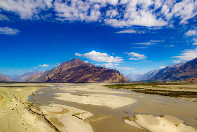 Scenic view of mountains against blue sky