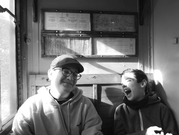 Two teen brothers laughing in an old train. 