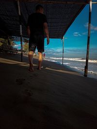 Seen from behind a man walking leaving footprints