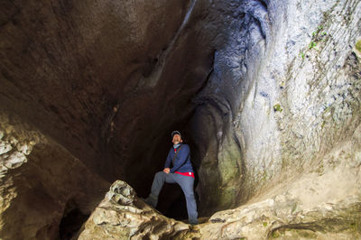 Full length of man sitting on rock