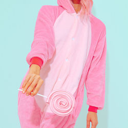 Unrecognizable pink pajamas party girl. lollipop lover. minimal. home relax style. kigurumi shop