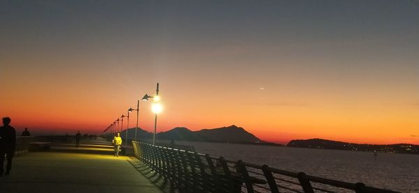 Pier over sea against sky during sunset