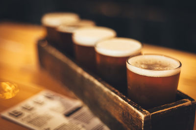 Beer glasses in wooden container on table at bar