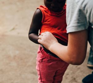 Midsection of man holding red while standing on land
