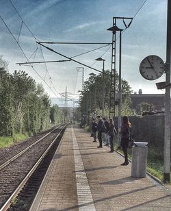 Railroad tracks against cloudy sky